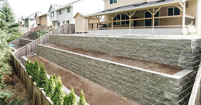 Multi-level block retaining wall behind a residential property